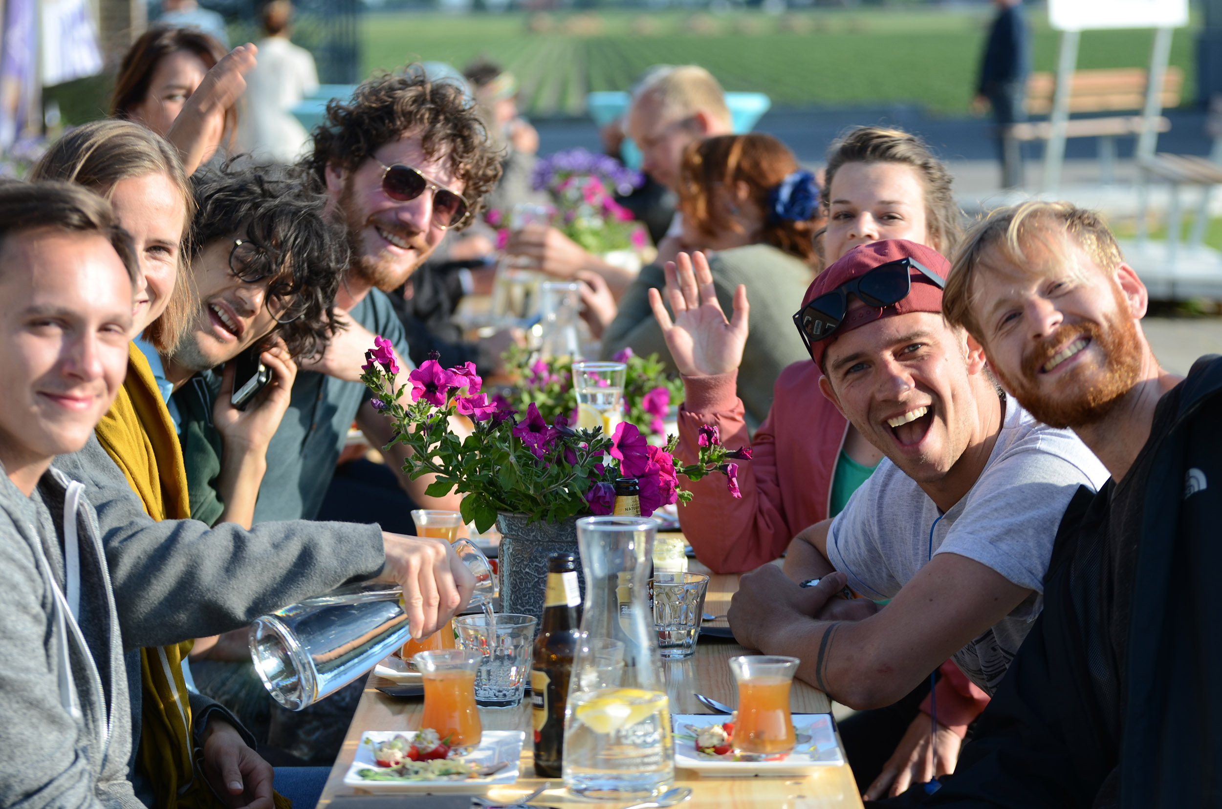 Blije mensen aan lange tafel bij trainingslocatie Leven van de Wind in Noord-Holland